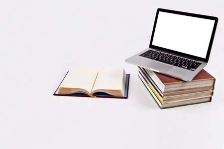 Laptop with blank screen and books on white background, education concept