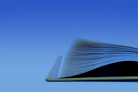 Open book on a blue background. Close-up. Selective focus.の写真素材