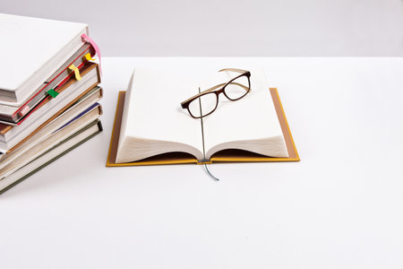 Stack of books and eyeglasses on white background. education conceptの写真素材