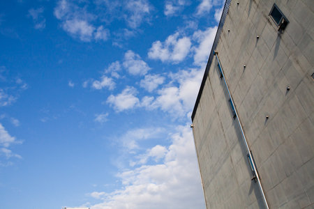 Modern office building against a blue sky with white clouds. Abstract background.