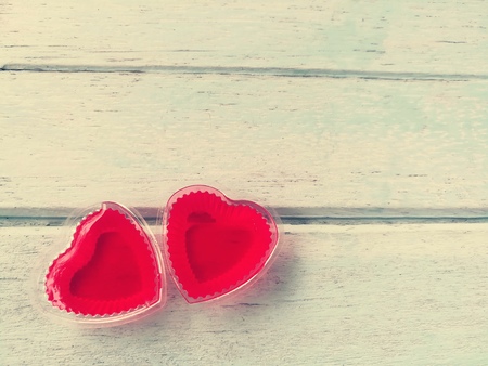 Couple cute red hearts made of jelly, placed together in the bottom left corner on blue wooden background,love is beautiful,Valentine dayの写真素材