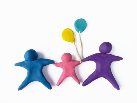 Plasticine clay made are the happy family,parents holding hand son or daughter and cute balloons on white backgroundの写真素材