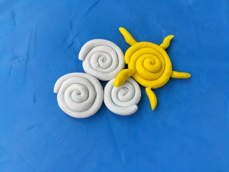 Plasticine clay made are beautiful sky sun and cloudÂ placed on blue background,cute dough naturalの写真素材