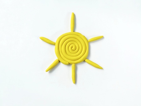 The sun shines yellow made from clay plasticine on white background,beautiful doughの写真素材