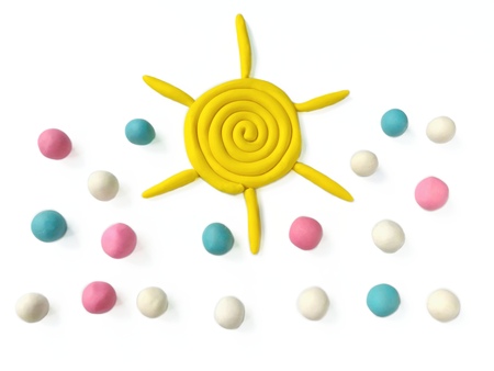 Yellow sun and sweet color snow made from plasticine clay on white backgroundの写真素材