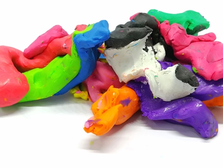 Multicolored plasticine clay mixed together in a strange shapes on a white background,abstract doughの写真素材