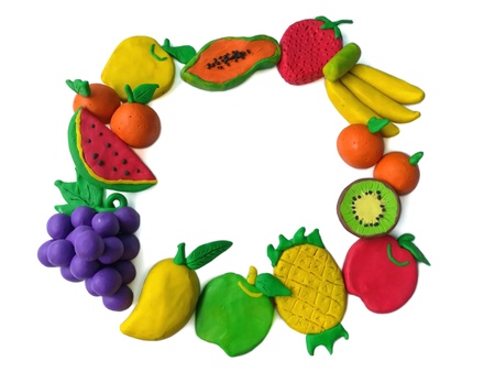 Colorful plasticine clay made are many kinds of fruit arranged as a frame on white backgroundの写真素材