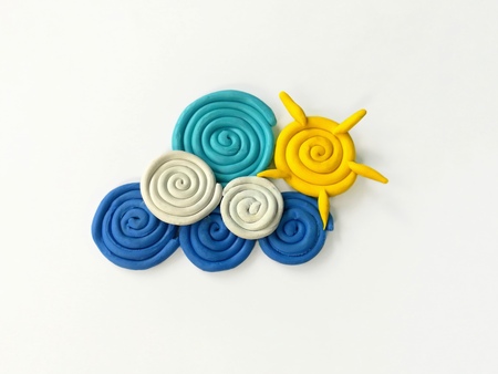 Clouds and sun made from clay plasticine dough on white background, roll up a circle arrange...