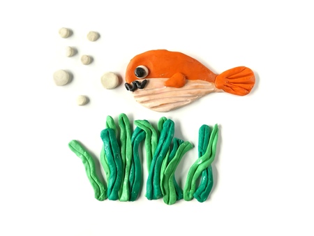 Beautiful underwater made from plasticine clay on white background, cute fish and seaweed doughの写真素材