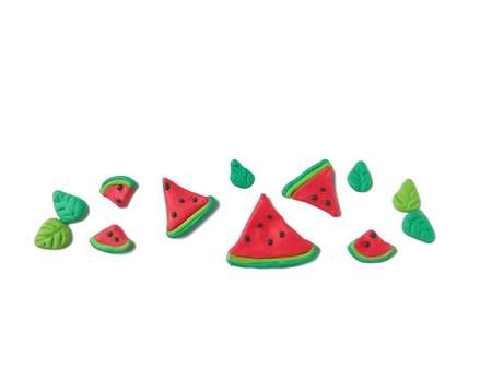 Delicious red watermelon slice and green leaf made from plasticine clay decorate are beautiful line...