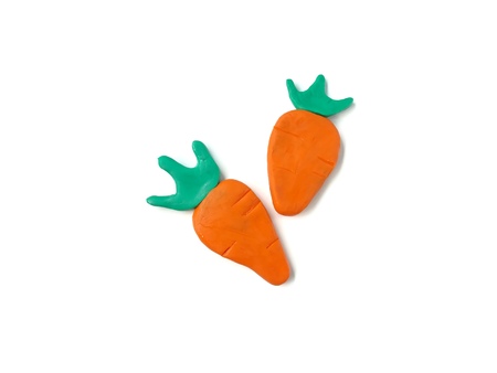 Delicious orange carrot made from plasticine clay on white background, are arranged beautiful fresh...