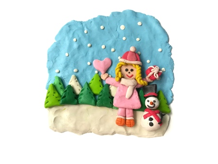 Happy little girl with Christmas festival and cute Snowman made from plasticine clay on beautiful view are on white background, snow falling from the sky gift heart and tree are doughの写真素材