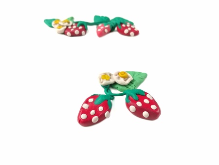 Colorful plasticine clay made are delicious strawberry and flower beautiful arranged on white background, fruit shape are doughの写真素材
