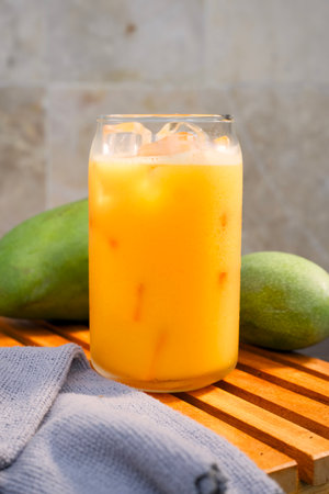 Portrait of a glass of mango juice placed on a wooden tray. Health drink conceptの写真素材