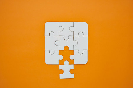 White jigsaw puzzle missing one central piece, symbolizing problem-solving and strategy.