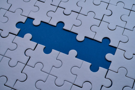 White interlocking puzzle pieces frame an empty space showing vibrant blue background.