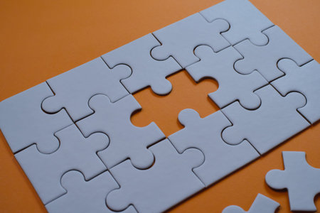 Gray jigsaw puzzle has a missing central piece, symbolizing challenges and needed completion.