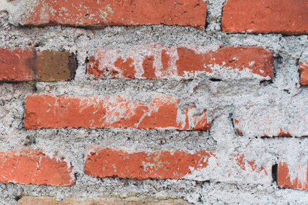 A close up view of a weathered red brick wall background.
