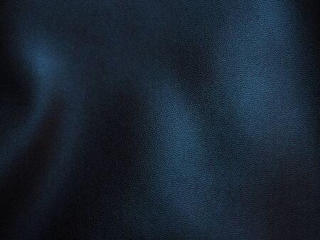 Folded crease wavy black faux leather grainy texture background, with light reflection and shadow, selective focusの写真素材