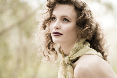 A soft, feminin, dreamy portrait of a young, vinage style woman with curly hair の写真素材