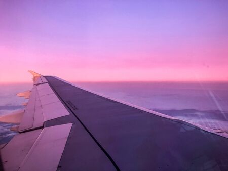 aerial sunrise over airplane wing in flight