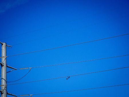 transmission tower with power lines and a blue skyの写真素材