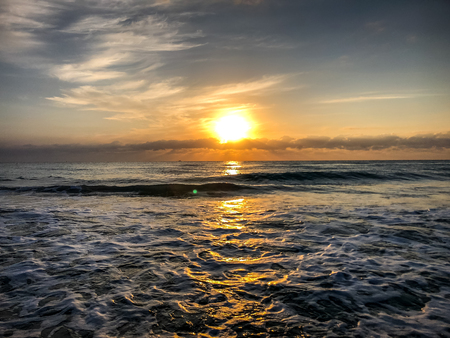 large orange sun rising out of the Ocean in the morningの写真素材