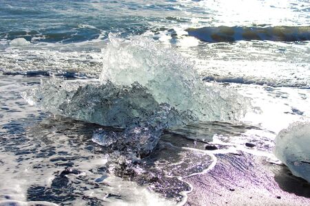 iceberg washed up on the black sand beach of Iceland's diamond beach near the Glacier Lagoonの写真素材