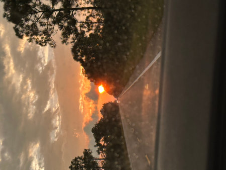 Reflection of the sun in the window of a car at sunsetの写真素材