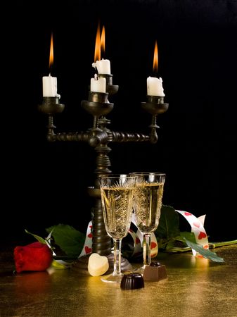 Candles, glasses with wine, rose on a black backgroundの写真素材