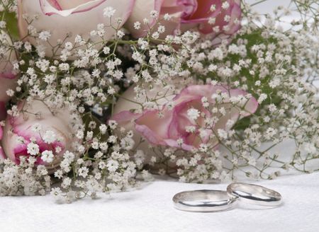 Bouquet  roses and weddings rings on a background white silkの写真素材