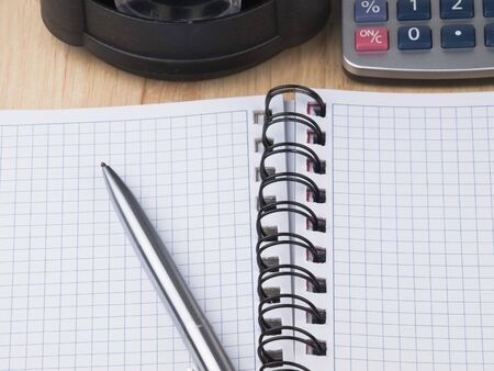 Opened business diary, pen and calculator