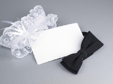 Card, bridal garter and bow  on a background white silkの写真素材
