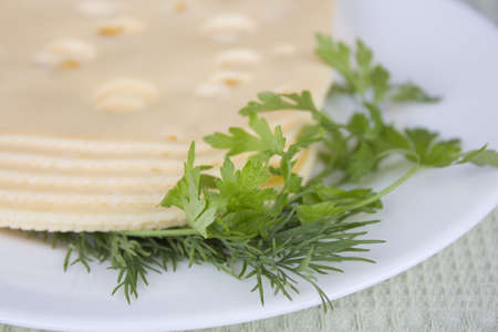 Plate with pieces cheese on a table-clothの写真素材