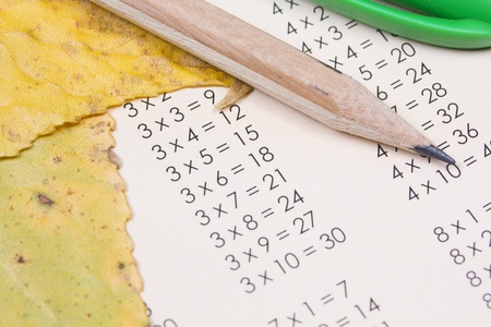 multiplication table, yellow autumn leaves and pencilの写真素材