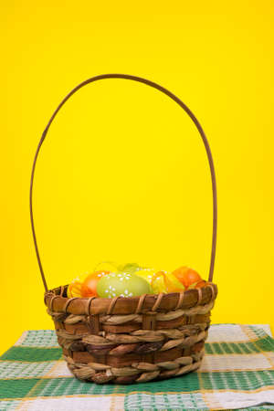 Easter eggs in a basket on an yellow  background