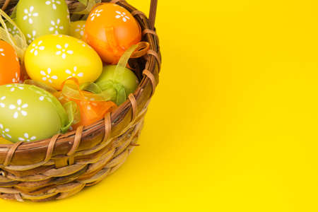 Easter eggs in a basket on an yellow  backgroundの写真素材