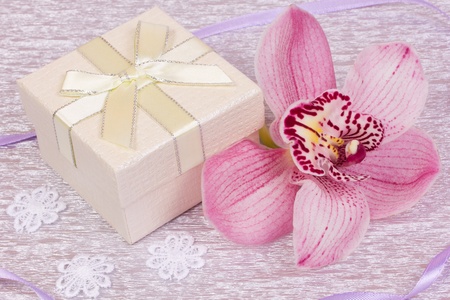 Box for gift and orchid on a silver background  の写真素材