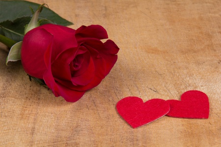 Red  rose and heart symbol on a wooden background