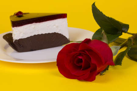 Piece of cake and roses on a yellow backgroundの写真素材