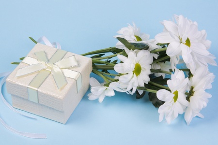Bouquet of white chrysanthemums and gift boxes on a blue backgroundの写真素材