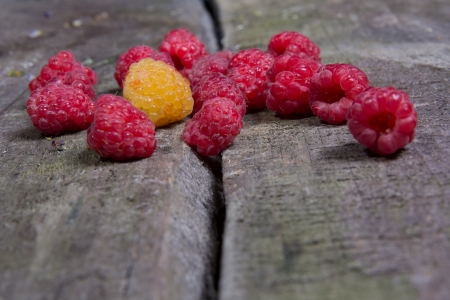 Ripe tasty raspberries on an old wooden tableの写真素材