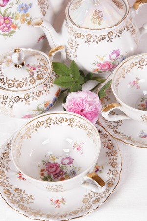 Antique floral tea set on a white tableclothの写真素材
