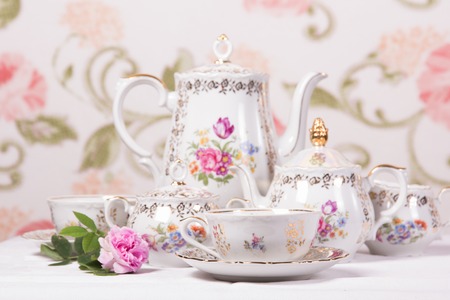 Antique floral tea set on a white tableclothの写真素材