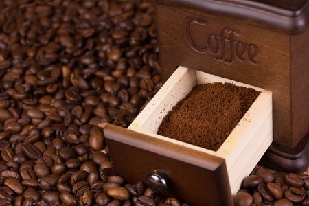 Vintage coffee grinder and a lot of roasted coffee beansの写真素材