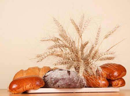 Fresh bread and wheat ears on the kitchen tableの写真素材