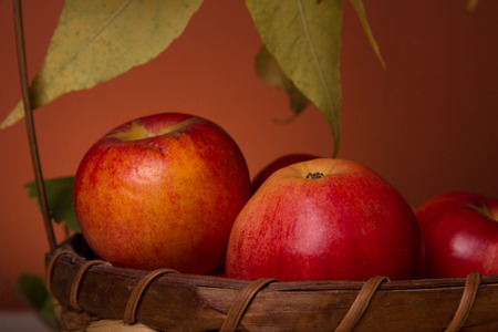 Red fresh apples in a wicker basketの写真素材