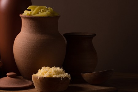 Grated cheese in a wooden bowl on the kitchen tableの写真素材