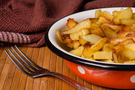 fried potatoes for cooking on an old kitchen tableの写真素材