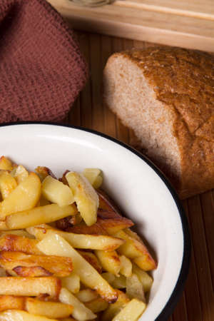 fried potatoes for cooking on an old kitchen tableの写真素材